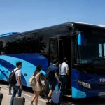 Grupo de viajeros subiendo a un autobús de Autocares Falcón León para realizar un transfer al aeropuerto de Sevilla.